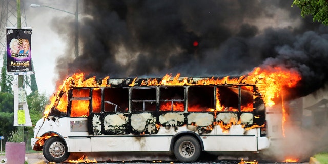 A burning bus, set alight by cartel gunmen to block a road, is pictured during clashes with federal forces following the detention of Ovidio Guzman, son of drug kingpin Joaquin 