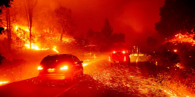 Embers fly across a roadway as the Kincade Fire burns through the Jimtown community of Sonoma County, Calif., on Thursday, Oct. 24, 2019.