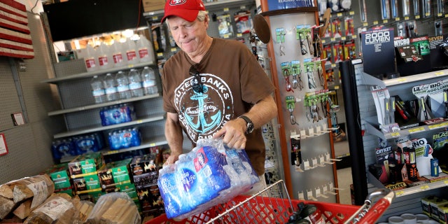 James Cooke is shown buying water bottles along with propane tanks and batteries at a ACE Hardware store as he prepares for a possible power shutdown in Los Gatos, Calif., on Tuesday, Oct. 8, 2019.