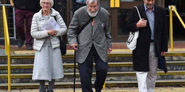 Extinction Rebellion activists Ursula Pethick, aged 83, John Lynes, 91, and John Halladay, 61, leave court where they were bailed to attend trial at a later date charged in connection with an environmental protest, in Folkestone, England, Wednesday Oct. 23, 2019. (Kirsty O'Connor/PA via AP)