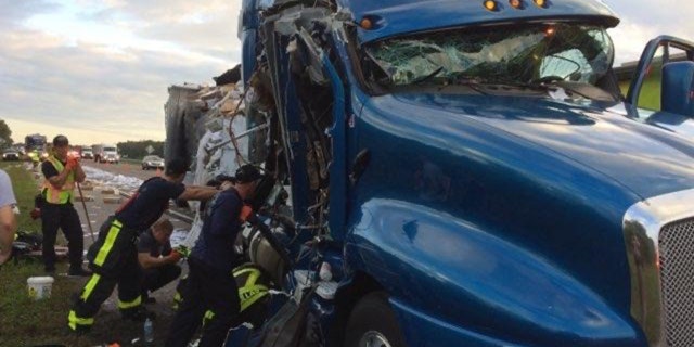 The mail-carrying truck slammed into a tractor-trailer carrying water and produce that was stopped in the southbound shoulder of I-75 on Monday, police said.