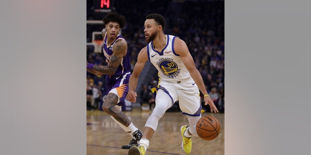 Phoenix Suns' Kelly Oubre Jr., left, guards Golden State Warriors' Stephen Curry during the first half of an NBA basketball game Wednesday, Oct. 30, 2019, in San Francisco.