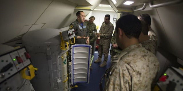 Lt. Fan Yang, left demonstrates the systems on board a P-8A Poseidon aircraft to members of the Royal Saudi Naval Forces on March 1, 2018.Â