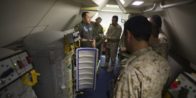 Lt. Fan Yang, left demonstrates the systems on board a P-8A Poseidon aircraft to members of the Royal Saudi Naval Forces on March 1, 2018. 