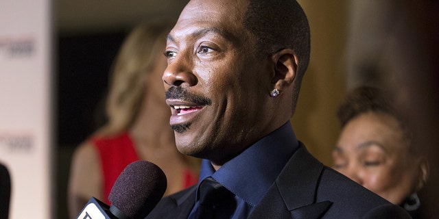 Eddie Murphy speaks to reporters as he arrives for the Mark Twain prize for Humor honoring Murphy at the Kennedy Center in Washington Oct. 18, 2015. 