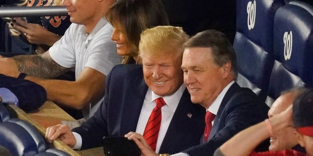 Sen. David Perdue, R-Ga., takes a selfie with President Donald Trump during the seventh inning of Game 5 of the baseball World Series between the Houston Astros and the Washington Nationals Sunday, Oct. 27, 2019, in Washington. (AP Photo/Pablo Martinez Monsivais)