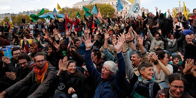 Protesters from Extinction Rebellion block a bridge Monday in Paris. (AP)