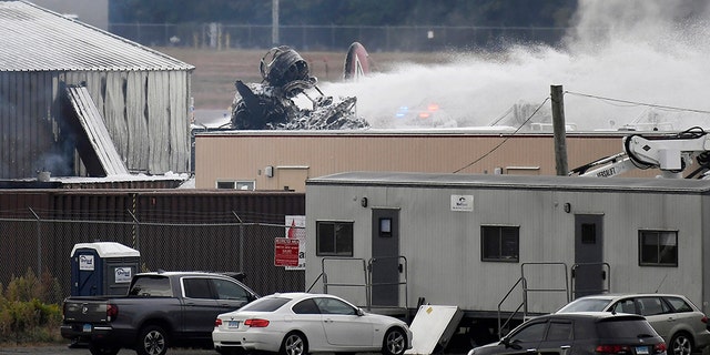 Emergency crews respond after a World War II-era bomber plane crashed at Bradley International Airport in Windsor Locks, Conn., Wednesday, Oct. 2, 2019.