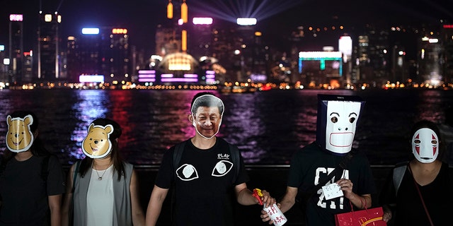 Hong Kong pro-democracy protesters are donning cartoon masks as they formed a human chain across the semi-autonomous Chinese city on Friday. (AP)