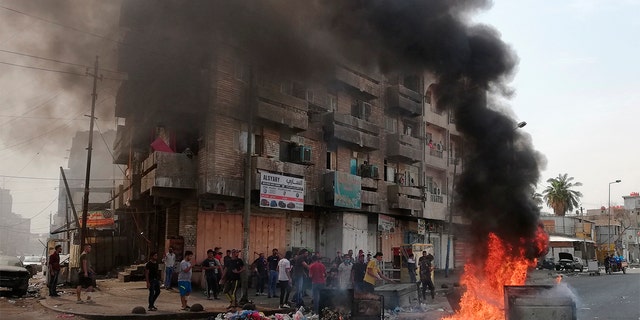Anti-government protesters setting a fire and blocking roads in Baghdad last Wednesday. (AP Photo/Hadi Mizban)