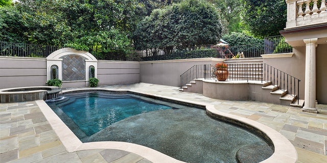 The property includes an in-ground swimming pool with a large terrace and an enclosed play area on the side.