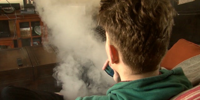 A young adult is shown vaping. E-cigarettes entered the U.S. marketplace in 2007-2008.