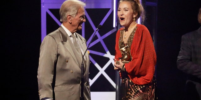Lauren Daigle, right, accepts the song of the year award from Pat Boone, left, during the Dove Awards on Tuesday, Oct. 15, 2019, in Nashville, Tenn.