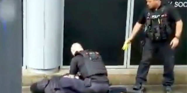In this image taken from mobile phone footage, police arrest a man outside the Arndale Center in Manchester, England, on Friday, after a stabbing incident that left three people injured.