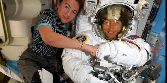 FILE - In this image released Friday, Oct. 4, 2019, by NASA, astronauts Christina Koch, right, and, Jessica Meir pose for a photo on the International Space Station. NASA has moved up the first all-female spacewalk to Thursday, Oct. 17, 2019, or Friday because of a power system failure at the International Space Station. (NASA via AP)