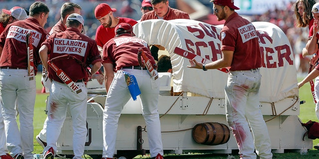 The Oklahoma Sooner Schooner flipped over during a touchdown celebration on the field during the first half of an NCAA college football game against West Virginia in Norman, Okla., Saturday, Oct. 19, 2019. (AP Photo/Alonzo Adams)