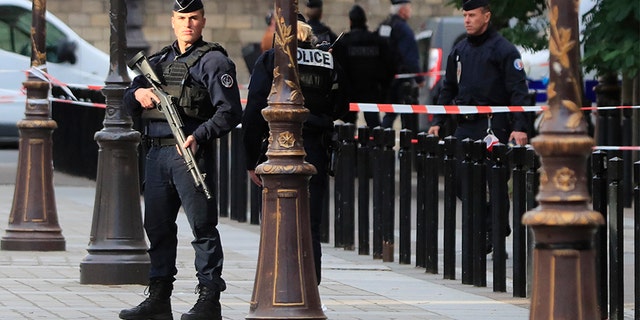 Police officers control the perimeter outside the Paris police headquarters on Thursday after an administrator armed with a knife attacked officers inside. (AP)