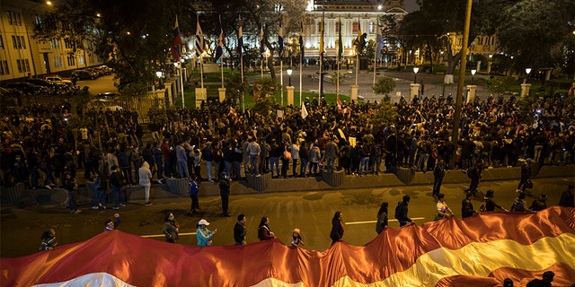 Demonstrators who had gathered to protest lawmakers pushing forward a vote to select an almost-full slate of new magistrates to the Constitutional Tribunal, continue outside Congress after President Martin Vizcarra dissolved the legislature in Lima, Peru, on Monday. (AP)