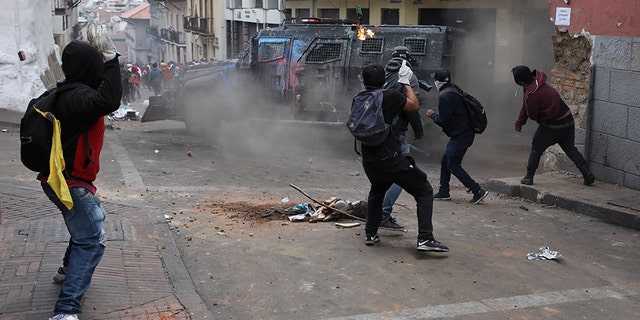 A petrol bomb bounces off an armored vehicle as it turns a corner in chase of protesters during clashes in downtown Quito, Ecuador, on Wednesday. (AP)