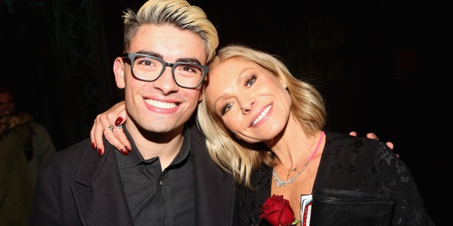 Kelly Ripa breaks down describing coronavirus quarantine, tearfully admits kids 'won’t hug' her 2 Michael Consuelos and Kelly Ripa pose backstage as Jake Shears of the rock group 'The Scissor Sisters' makes his Broadway debut in the hit musical 'Kinky Boots' on Broadway at The Al Hirschfeld Theatre on January 8, 2018 in New York City.