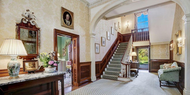 Featuring high ceilings, the space includes multiple seating areas and a large formal dining room with floor-to-ceiling windows.