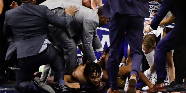 Minnesota Timberwolves' Karl-Anthony Towns lies on the court after an altercation with Philadelphia 76ers' Joel Embiid during the second half of an NBA basketball game Wednesday, Oct. 30, 2019, in Philadelphia. Both players were ejected. The 76ers won 117-95. (AP Photo/Matt Rourke)
