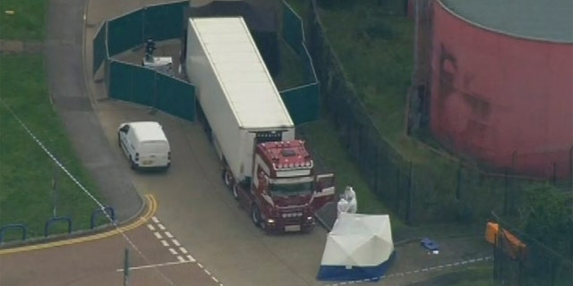 FILE - In this Oct. 23, 2019, file photo, police forensic officers attend the scene after a truck was found to contain a large number of dead bodies in Thurrock, South England. The discovery in England of the bodies of 39 people believed to be from China lays bare some crucial but sometimes overlooked facts about China's development as a rising global power that has elevated hundreds of millions of its citizens to the middle classes. (UK Pool via AP, File)