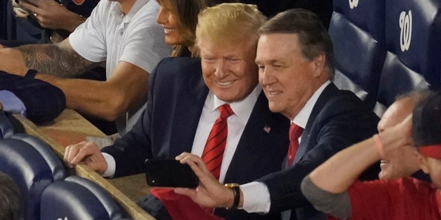 Sen. David Perdue, R-Ga., takes a selfie with President Donald Trump during the seventh inning of Game 5 of the baseball World Series between the Houston Astros and the Washington Nationals Sunday, Oct. 27, 2019, in Washington. (AP Photo/Pablo Martinez Monsivais)