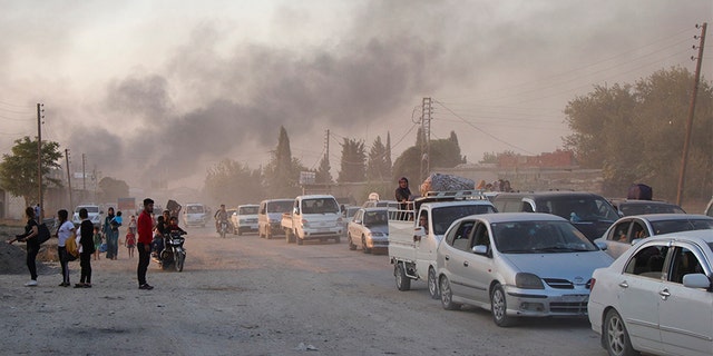Syrians flee shelling by Turkish forces in Ras al-Ayn, northeast Syria on Wednesday.