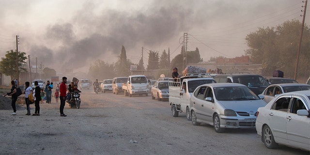 Syrians flee shelling by Turkish forces in Ras al-Ayn, northeast Syria on Wednesday.