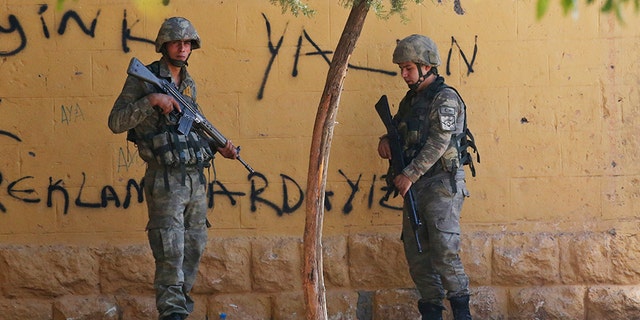 Turkish soldiers stand at the border with Syria in Akcakale, Sanliurfa province, southeastern Turkey, on Thursday.