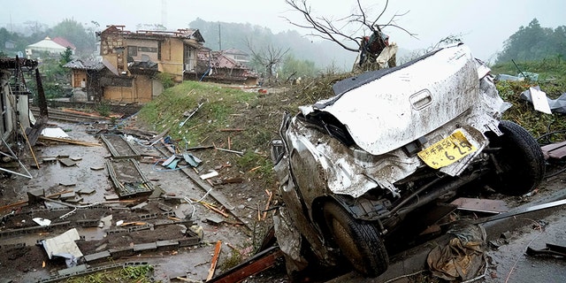 A damaged car lies on the ground following a strong wind in Ichihara, Chiba, near Tokyo Saturday, Oct. 12, 2019. Under gloomy skies, a tornado ripped through Chiba on Saturday.(Kyodo News via AP)
