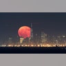 The moon rises behind Lower Manhattan and One World Trade Center in New York City as seen from Green Brook Township, New Jersey, Oct 15, 2019.