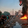 Anti-government protesters set fires and close a street during a demonstration in Baghdad, Iraq, Oct. 3, 2019. 