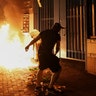 Protesters throw petrol bombs outside the Tsuen Wan police station in Hong Kong, Oct. 2, 2019. 