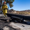 Firefighters with Cal Fire examine a burned down low voltage power pole during the Tick Fire, Thursday, Oct. 25, 2019, in Santa Clarita, Calif. An estimated 50,000 people were under evacuation orders in the Santa Clarita area north of Los Angeles as hot, dry Santa Ana winds howling at up to 50 mph (80 kph) drove the flames into neighborhoods (AP Photo/ Christian Monterrosa)