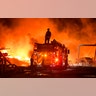 A firefighter stops to look at a wall of fire while battling a grass fire in Knightsen, California, Oct. 27, 2019. 