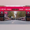 Eliud Kipchoge celebrates as he crosses the finish line to become the first person to run a marathon in under 2 hours in Vienna, Oct.12, 2019.