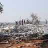 People look at a destroyed houses near the village of Barisha. (AP Photo/Ghaith Alsayed)