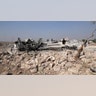 People look at a destroyed houses near the village of Barisha. (AP Photo/Ghaith Alsayed)