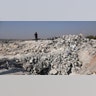 People look at a destroyed houses near the village of Barisha. (AP Photo/Ghaith Alsayed)