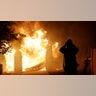 A firefighter prepares to fight a wildfire as it overtakes a home Thursday, Oct. 24, 2019, in Santa Clarita, Calif. The flames are fed by dry winds that are predicted to strengthen across the region. (AP Photo/Marcio Jose Sanchez)