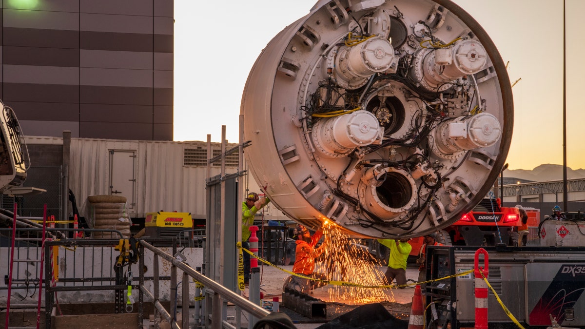 Workers cut the storage rack from the base of the drill head as the Boring Company prepares to lower the drill head for the People Mover tunnel which will connect convention halls as part of the LVCCD Phase 2 construction in the Red Lot east of the South Hall at the Las Vegas Convention center on Monday, Oct. 28, 2019.