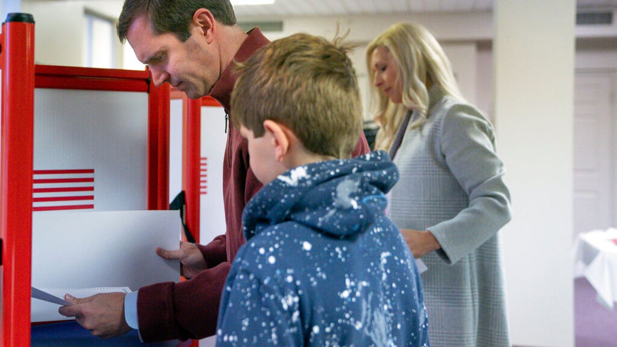 Kentucky Attorney General and Democratic Gubernatorial candidate Andy Beshear studies his ballot at the Knights of Columbus polling location Tuesday, Nov. 5, 2019, in Louisville, Ky. Kentucky's voters are now deciding the political grudge match between Republican Gov. Matt Bevin and Beshear. (AP Photo/Bryan Woolston)