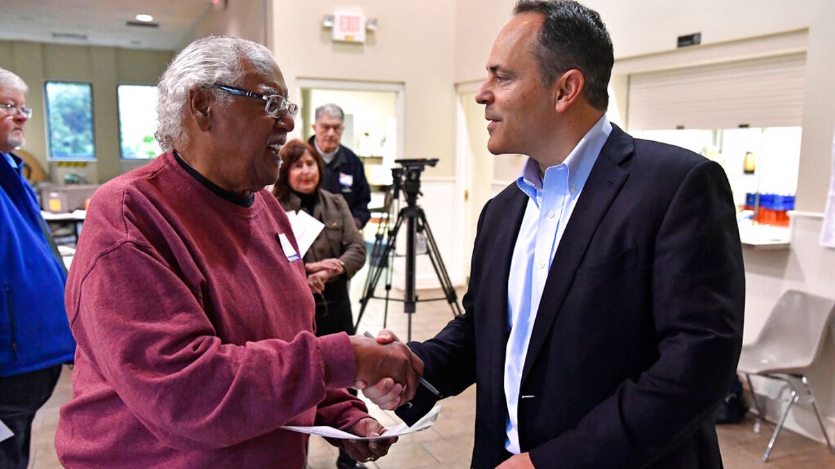 Kentucky Governor and Republican gubernatorial candidate Matt Bevin, right, shakes hands with a poll worker after casting his ballot in the state's general election in Louisville, Ky., Tuesday, Nov. 5, 2019. (AP Photo/Timothy D. Easley)