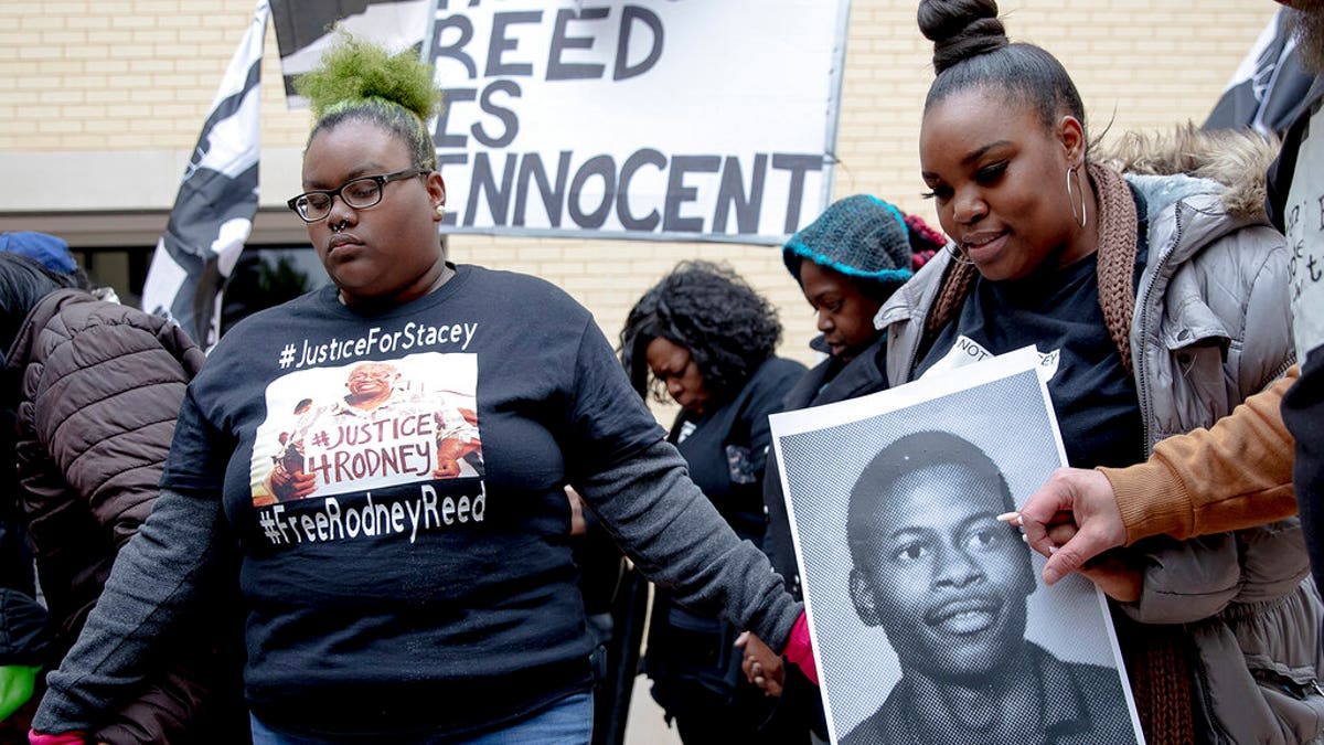 People hold hands while praying during a protest against the execution of Rodney Reed on Wednesday, Nov. 13, 2019, in Bastrop, Texas. Reed is scheduled to die later this month for the 1996 killing of a 19-year-old woman in Central Texas.