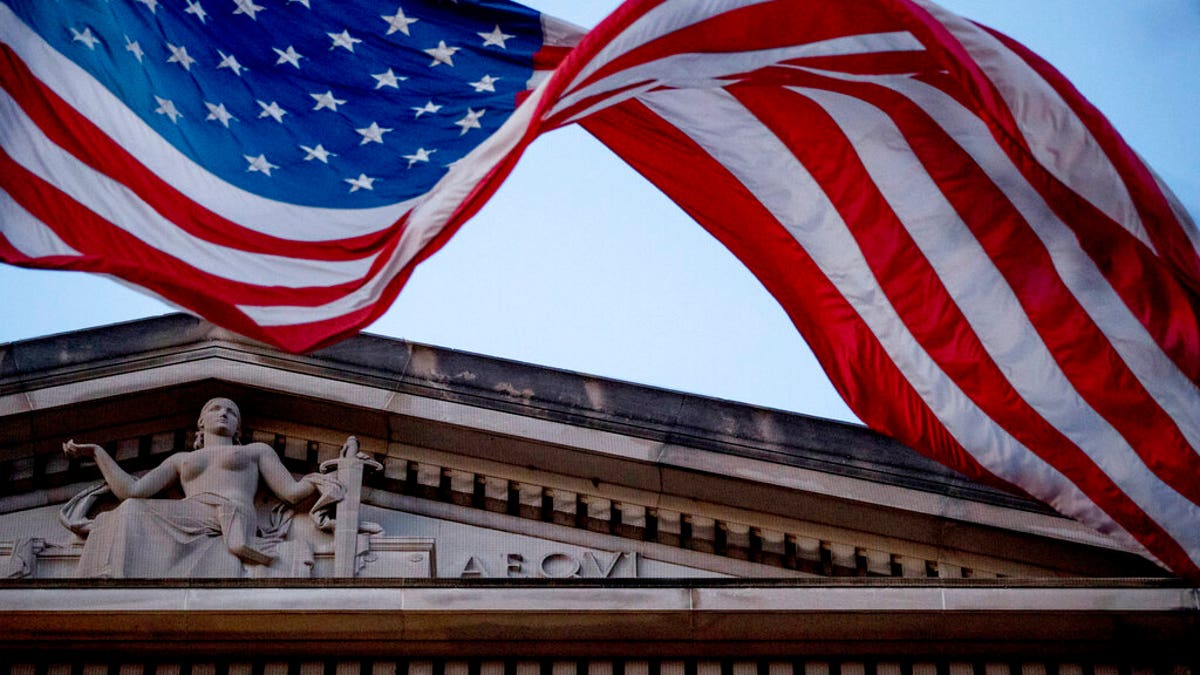 FILE - In this March 22, 2019 file photo, an American flag flies outside the Department of Justice in Washington. (AP Photo/Andrew Harnik)