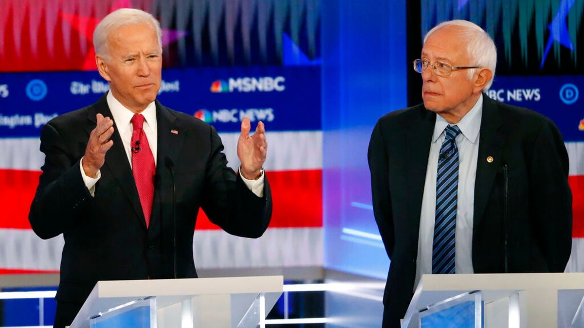 Biden speaks as Sanders listens during a Democratic presidential primary debate, Nov. 20, 2019, in Atlanta. (AP Photo/John Bazemore)