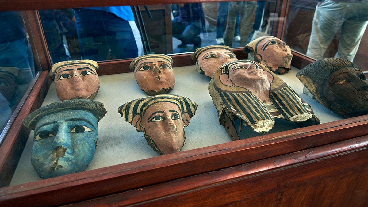 Wooden and clay mummies masks are displayed in Saqqara, south Giza, Egypt. Saturday, Nov. 23, 2019. The new discovery was displayed at a makeshift exhibition at the famed Step Pyramid of Djoser in Saqqara, south of Cairo, near the mummies and other artifacts were found in a vast necropolis. (AP Photo/Hamada Elrasam)