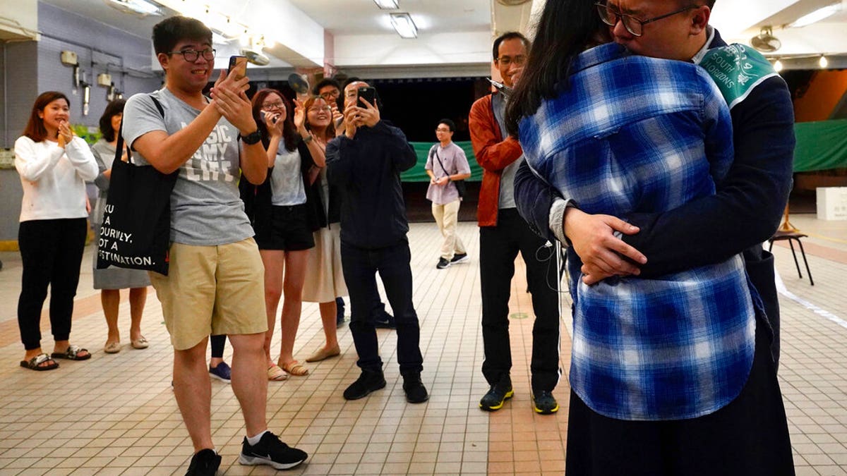 Pro-democracy candidate James Yu hugging his girlfriend after winning his seat in district council elections in Hong Kong, early Monday. (AP Photo/Vincent Yu)